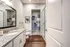 Modern bathroom with granite countertop, spacious shower, and elegant walk-in closet, showcasing sleek design and comfort.