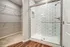 Modern bathroom with elegant subway tiles and walk-in shower, adjacent to a spacious walk-in closet with ample shelving.