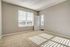 Bright and airy bedroom with large windows, plush carpet, and modern design, perfect for relaxation and comfort.
