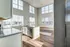 Bright, airy open-concept kitchen with granite countertops and ample natural light from expansive windows.