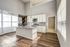 Bright modern kitchen with elegant granite countertops, high ceilings, and sleek stainless steel appliances, ideal for sophisticated living.