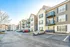 Modern apartment complex with stylish balconies, ample parking, and picturesque architecture under a clear blue sky.