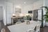 Sleek modern kitchen with stainless steel appliances, elegant white cabinetry, and a cozy dining area with a lush plant centerpiece.