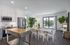 Modern open-concept kitchen and dining area with elegant decor, stainless steel appliances, and a view of a lush garden.