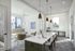 Bright and modern meeting room with sleek white conference table, elegant pendant lighting, and cozy seating area.