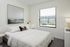 Bright and cozy bedroom featuring a plush bed, modern decor, and a scenic window view.