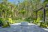 Serene outdoor patio with lush greenery, stylish green chairs, and a central fire pit, perfect for relaxation.