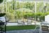 Inviting outdoor patio featuring cozy wicker chairs, a chic umbrella, and a modern grill, perfect for relaxation amidst lush greenery.
