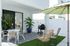 Chic outdoor patio space with stylish furniture, lush greenery, and a barbecue area under a vibrant umbrella.