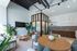 Bright and modern living room with high ceilings, sleek furnishings, and lush indoor plants at 80 On The Commons.