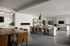 Elegant open-concept living and dining area with modern decor, featuring a sleek fireplace, stylish pendant lighting, and cozy seating arrangement.