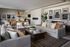 Chic open-plan living room features plush sofas, elegant dining set, modern art pieces, and ambient fireplace, creating a warm and inviting atmosphere.