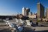Rooftop terrace offering stunning city skyline views with comfortable white chairs for relaxation under a clear blue sky.