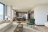 Bright and modern open-plan living area with a stylish kitchen, cozy seating, and floor-to-ceiling windows offering stunning views.