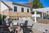 Charming outdoor patio with fire pit, elegant seating, and a modern barbecue area, perfect for entertaining.