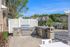 Charming outdoor patio with modern grill, stylish stone countertops, and scenic pond views, perfect for entertaining.