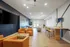 Modern communal living area featuring stylish armchairs, sleek TV setup, and chic bar seating, perfect for relaxation and entertainment.