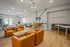 Inviting communal space featuring modern orange leather chairs, a sleek bar with yellow stools, and a foosball table for entertainment.