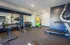 Modern fitness room featuring state-of-the-art equipment including treadmills, weights, and exercise balls with mirrored walls for an expansive feel.