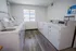 Bright and inviting laundry room featuring modern washers and dryers with a large window for natural light.