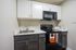 Modern kitchen with sleek black and white cabinets, shiny sink, and a state-of-the-art oven with built-in microwave.