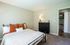 Tranquil bedroom with elegant decor, featuring cozy bed setup, modern dresser, and soft lighting.