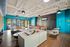 Modern community lounge featuring a plush sectional sofa, vibrant teal walls, and a stylish pool table, perfect for relaxation and social gatherings.