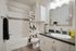 Elegant bathroom featuring modern fixtures, a sleek granite countertop, and a stylish geometric shower curtain.