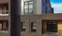 Modern apartment exterior with elegant brickwork, large windows, and a cozy balcony.
