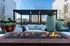 Chic rooftop patio featuring a cozy fire pit, stylish seating, and lush planters, perfect for relaxation and gatherings.