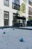 Modern apartment exterior featuring a stylish bocce ball court with sleek windows and elegant landscaping.