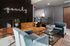 Elegant and modern living room featuring a plush mustard sofa, stylish blue armchairs, and chic glass coffee table, enhanced by ambient lighting and contemporary wall decor.