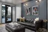 Modern living room with elegant black leather sofa, geometric art decor, and large glass doors opening to a stylish patio.
