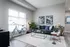 Chic and modern urban living room with sleek couch, artistic decor, natural light, and stylish furnishings.