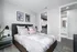 Elegant bedroom with modern decor, cozy bed, and access to a spacious walk-in closet and en-suite bathroom.