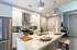 Sleek modern kitchen with stainless steel appliances, elegant lighting, and a stylish breakfast bar perfect for entertaining.