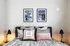 Cozy bedroom featuring modern decor, stylish black and white artwork, and plush pillows creating a welcoming ambiance.