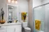 Bright and elegant bathroom featuring modern fixtures, glass-enclosed shower, and vibrant yellow accents.
