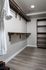 Elegant walk-in closet with sleek wooden shelving and abundant storage space, featuring modern lighting and stylish flooring.