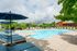 Inviting outdoor pool area with stylish sun loungers and vibrant greenery, perfect for relaxation and leisure.