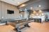 Stunning entertainment area featuring a sleek billiard table, luxurious seating at a marble-topped bar, and modern lighting in a stylish open-concept layout.