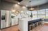 Luxurious modern kitchen with sleek marble countertops, elegant lighting, and stylish bar seating. Ideal for entertaining.