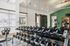 Modern gym facility with mirrored walls, dumbbells, kettlebells, and exercise equipment in a well-lit, inviting space.