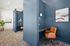 Modern workspace with sleek navy walls, stylish orange chairs, and soft lighting, perfect for productive work sessions.