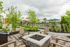 Inviting outdoor patio with cozy fire pit, surrounded by lush greenery and stylish seating, perfect for relaxation and gatherings.