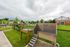 Charming community dog wash station with lush green landscape and cozy neighborhood backdrop.