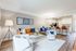 Modern open-concept living room featuring a cozy leather sofa, plush chairs, and stylish dining area with elegant lighting.