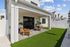 Charming outdoor patio area with stylish wooden chairs and table on green lawn, perfect for relaxation and entertaining.