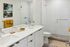 Elegant and modern bathroom showcasing a pristine white double vanity, stylish glass shower, and vibrant yellow accents.