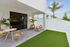 Charming outdoor patio with modern furniture, vibrant greenery, and elegant fencing, offering a serene suburban escape.